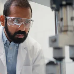 A young ethnic male scientist is doing research and working in a laboratory.