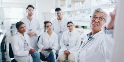 Manager leading team discussion in laboratory setting