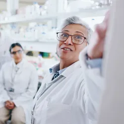 Manager leading team discussion in laboratory setting