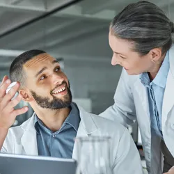 Lab manager and worker engaging in conversation about technology