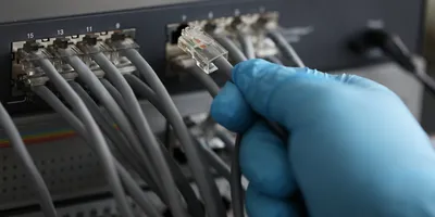 Technician connecting lab equipment with network cables.