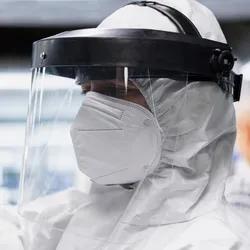 Laboratory technician wearing personal protective equipment while handling a sample.