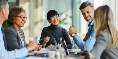 Group of happy multiracial colleagues communicating during a meeting in the office, representing leaders addressing staff needs