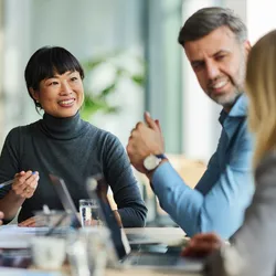 Group of happy multiracial colleagues communicating during a meeting in the office, representing leaders addressing staff needs