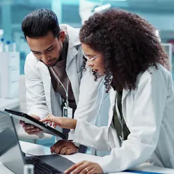 Scientists discussing AI research methods in a biomedical lab
