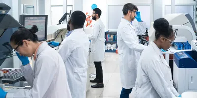 Multiracial team of five scientists working at laboratory