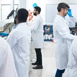 Multiracial team of five scientists working at laboratory