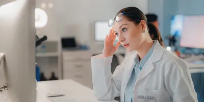 A scientist in a lab showing signs of stress due to environmental factors