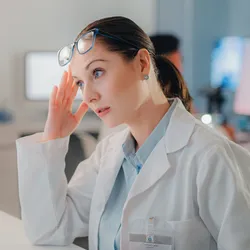 A scientist in a lab showing signs of stress due to environmental factors