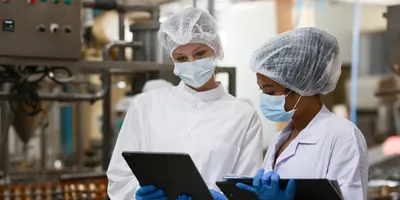 two food scientists looking over data on tablets