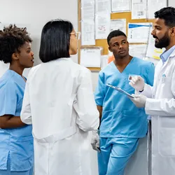 Group of four lab staff members openly talking with each other, representing a culture of psychological safety.