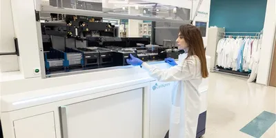 Female researcher using the The CellXpress.ai Automated Cell Culture System in the lab