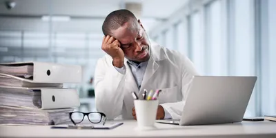 Lab employee showing signs of stress from psychosocial hazards
