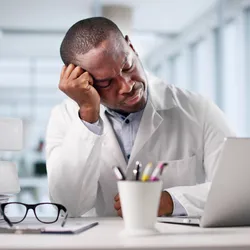 Lab employee showing signs of stress from psychosocial hazards