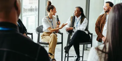 A group of conference attendees participating in a group discussion about AI lab uses