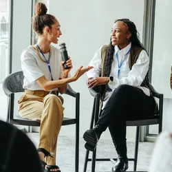 A group of conference attendees participating in a group discussion about AI lab uses