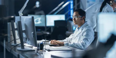 Researcher in lab coat working with lab automation tools