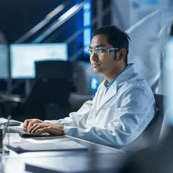 Researcher in lab coat working with lab automation tools