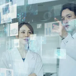Two lab researchers discuss AI data.