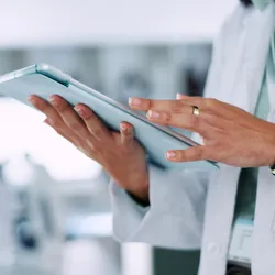 Scientist using a tablet for LIMS customization in a laboratory