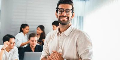 Agile leader standing in front, with his team working independently behind him.