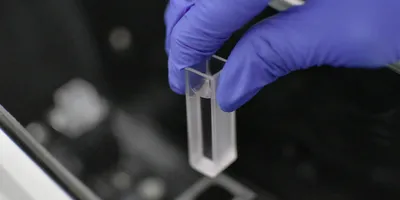 Analyst is loading a sample into a testing machine in a laboratory