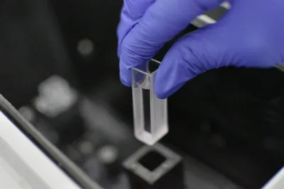 Analyst is loading a sample into a testing machine in a laboratory