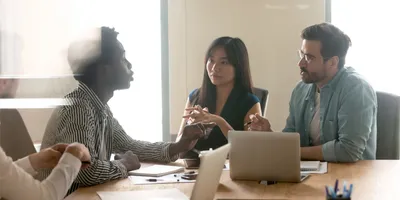 Multiethnic millennial colleagues dispute and talk through their thoughts on a project launch in office