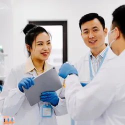 Three lab professionals effectively communicating in the lab.
