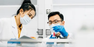 Two Asian scientists working together in lab.