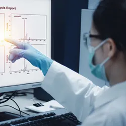 Scientist analyzing mass spectrometry data on a computer screen