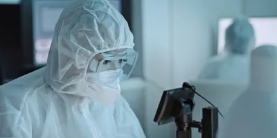 Laboratory worker in PPE managing heat stress risks.