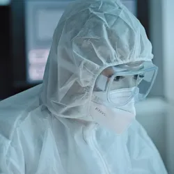 Laboratory worker in PPE managing heat stress risks.