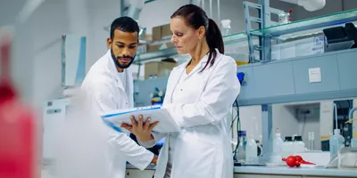 Lab technicians discussing risk assessment procedures.