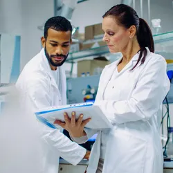 Lab technicians discussing risk assessment procedures.