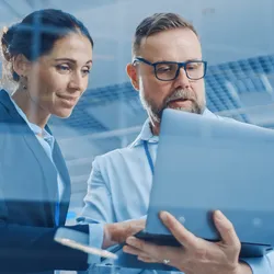 Stylish Confident Businesswoman and Businessman Working on a Project, Man Holds Laptop Computer