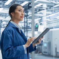 Focused Asian Engineer Monitoring and Analyzing Conditions in a laboratory on Tablet Device