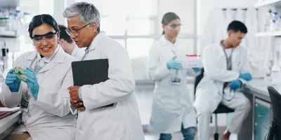 Lab personnel engaged in scientific discussion and management.