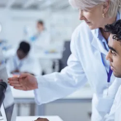 Lab manager providing guidance to a young researcher