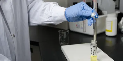 Close up on Laboratory worker filling tube glass with medical liquid using pipette
