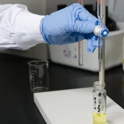 Close up on Laboratory worker filling tube glass with medical liquid using pipette
