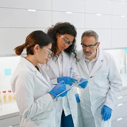 Three lab professionals discussing safety procedures
