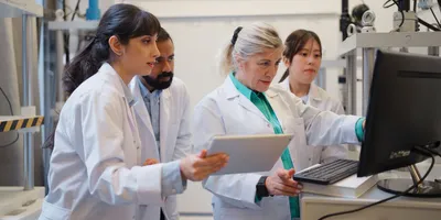Researchers collaborating in a laboratory using multi-agent AI technology.