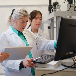Researchers collaborating in a laboratory using multi-agent AI technology.