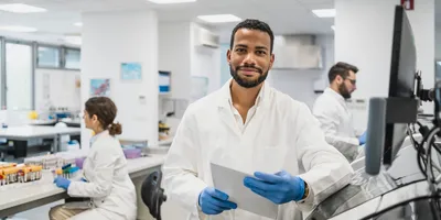 Smiling researcher in a lab, showcasing a safety-oriented atmosphere
