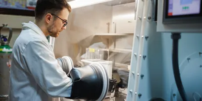 Male scientist using glove box