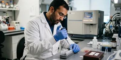 A researcher prepares antibody reagents at a laboratory bench, illustrating the panel development work that dominates spatial proteomics timelines.