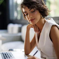 Professional woman working on laptop, focusing on her career plan