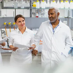 Five scientists standing in the lab, discussing a lab design project