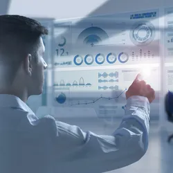 Back view of young businessman touching digital interface with financial graphs on blurry office interior background